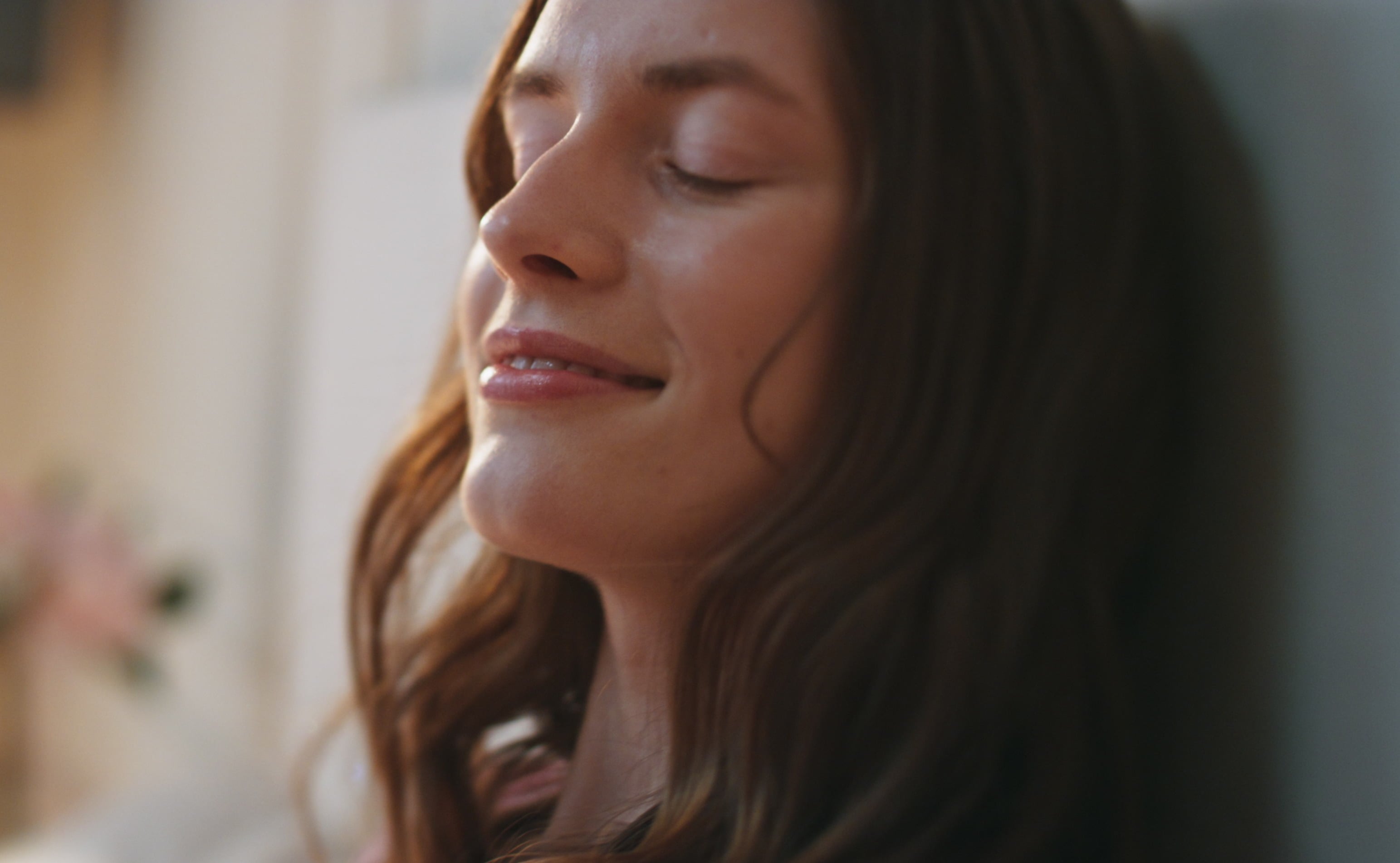 Close-up of a woman with her eyes closed, enjoying a calm moment of relaxation, mindfulness, and emotional wellbeing.